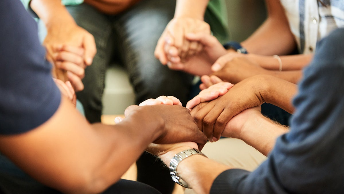 Diverse group holding hands