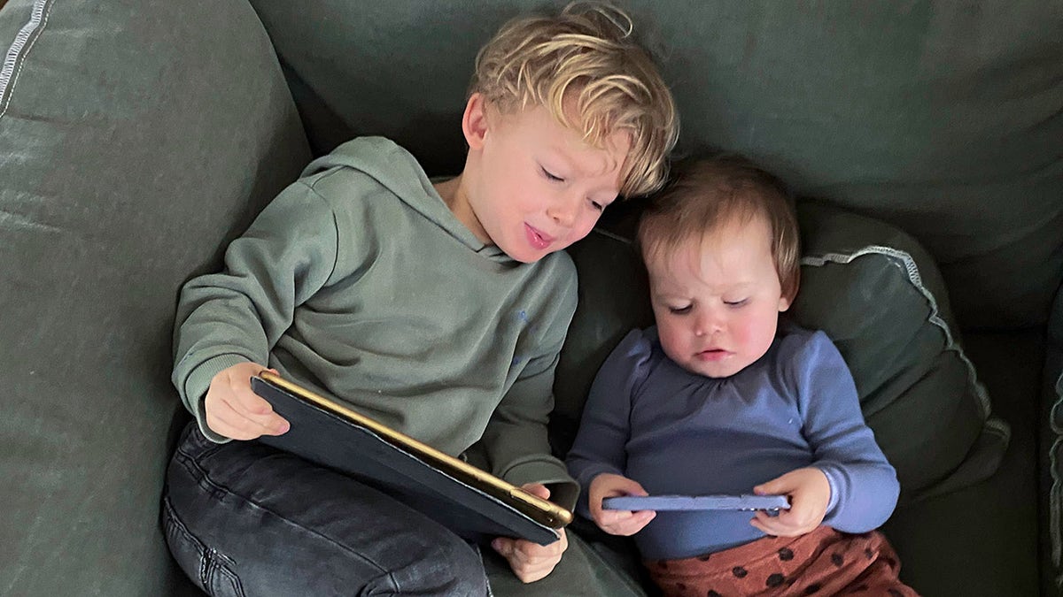 two small children and screens