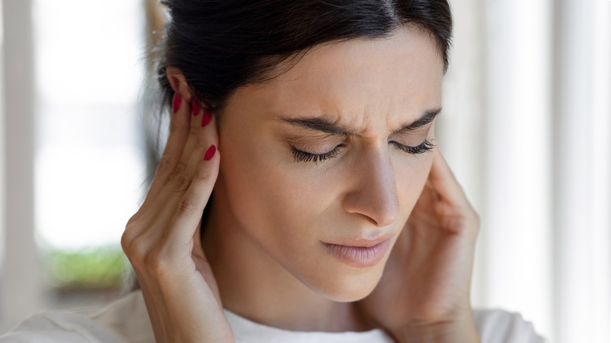 Woman holding ears