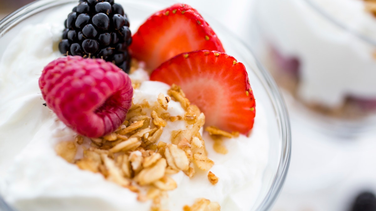 Breakfast parfait made from Greek yogurt and granola topped with fresh berries.