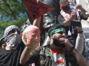 Anti-Israel agitator in Hamas headband holds up bloodied Biden face mask steps from White House