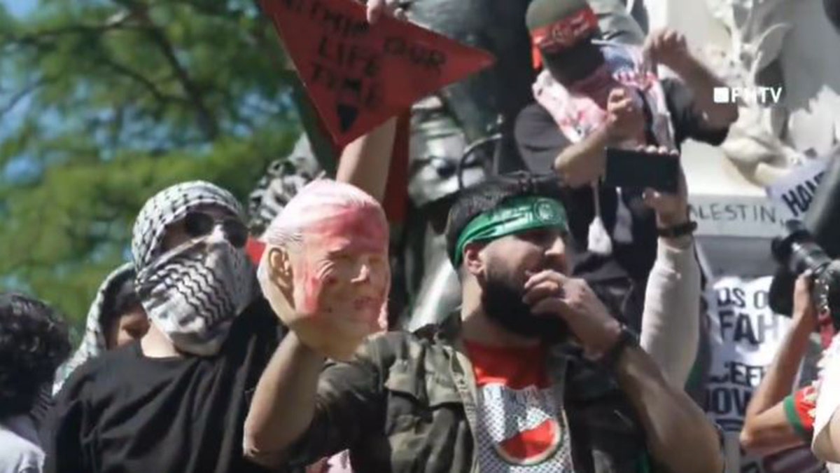 Anti-Israel agitator in Hamas headband holds up bloodied Biden face mask steps from White House