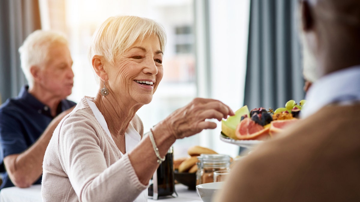 Older woman eating fruit