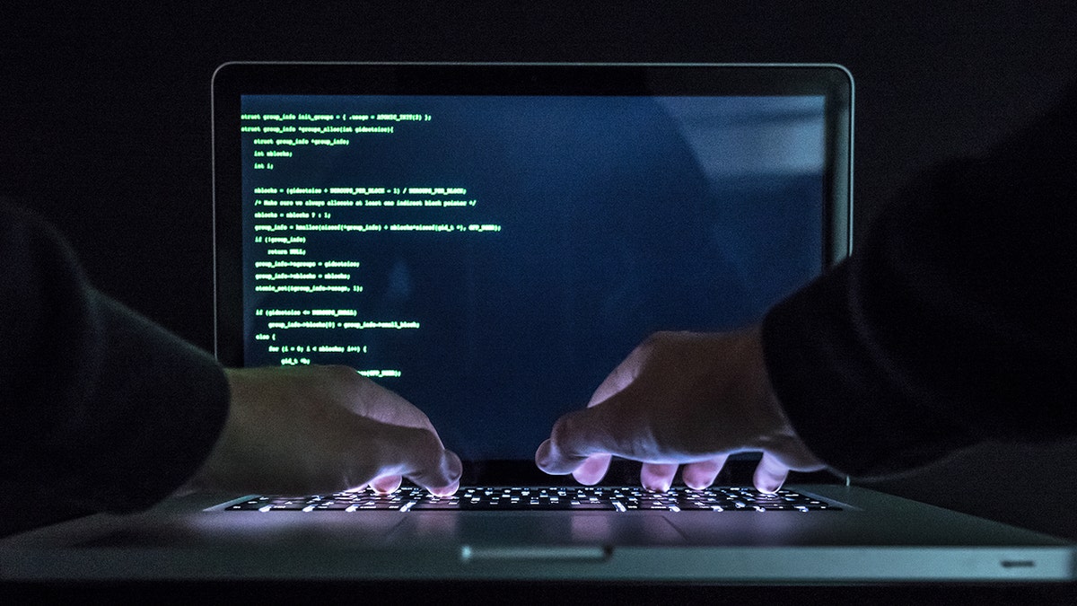 Hacker typing in code.