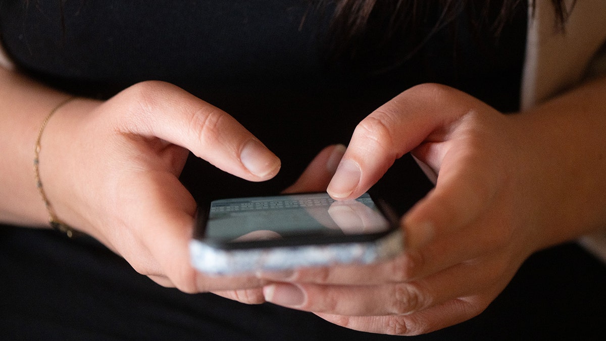 Woman typing on her phone.