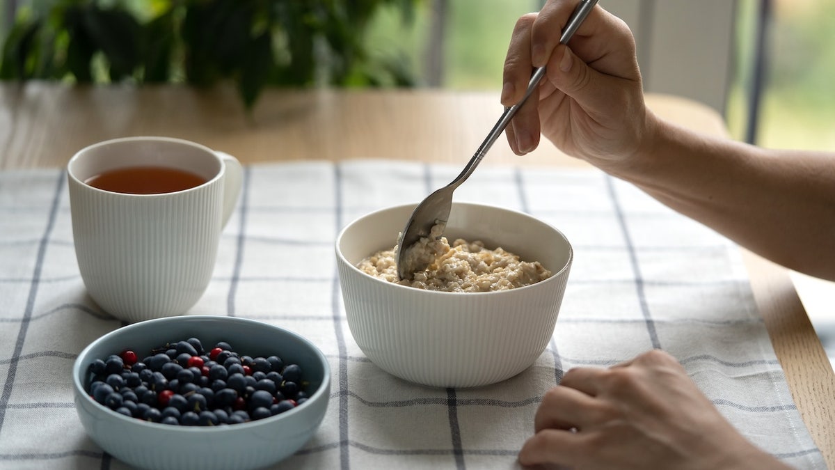 Woman at table eating oatmeal