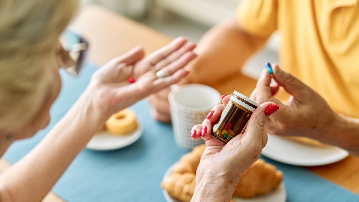 People taking supplements at table