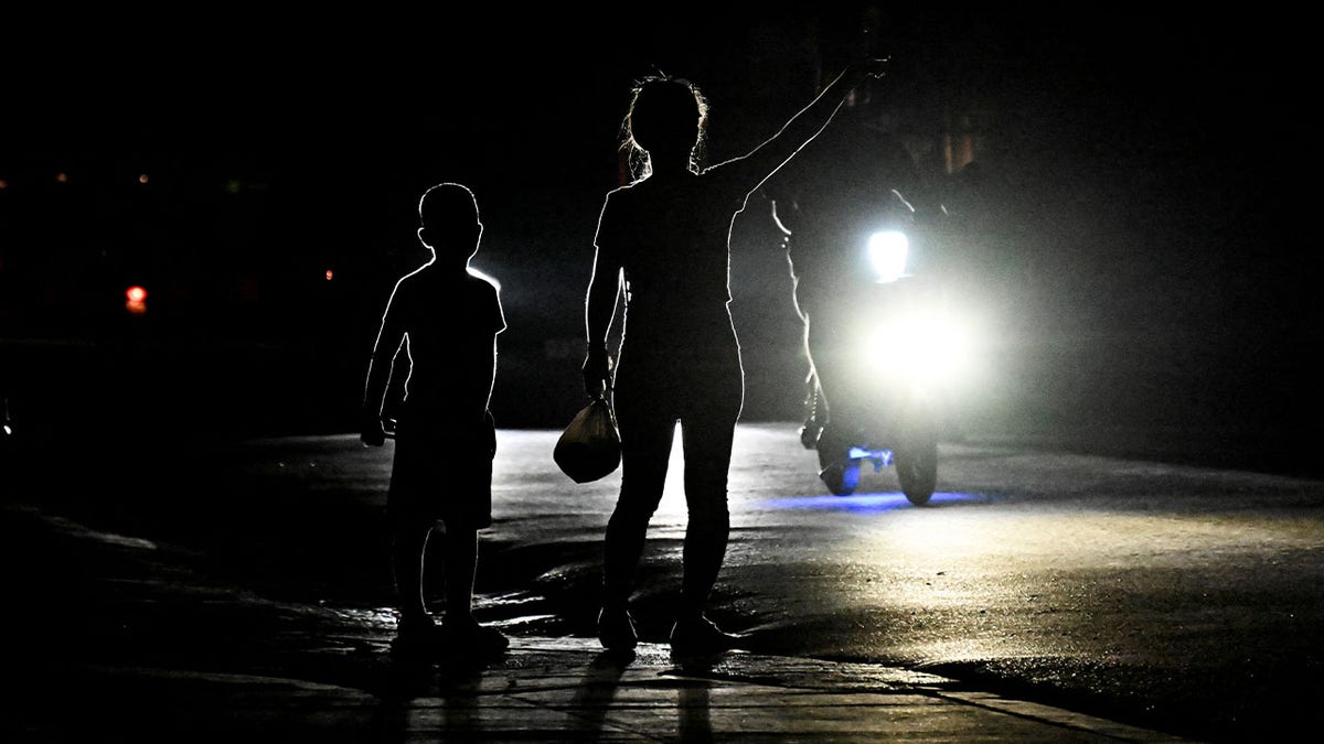 people signaling a car during a blackout