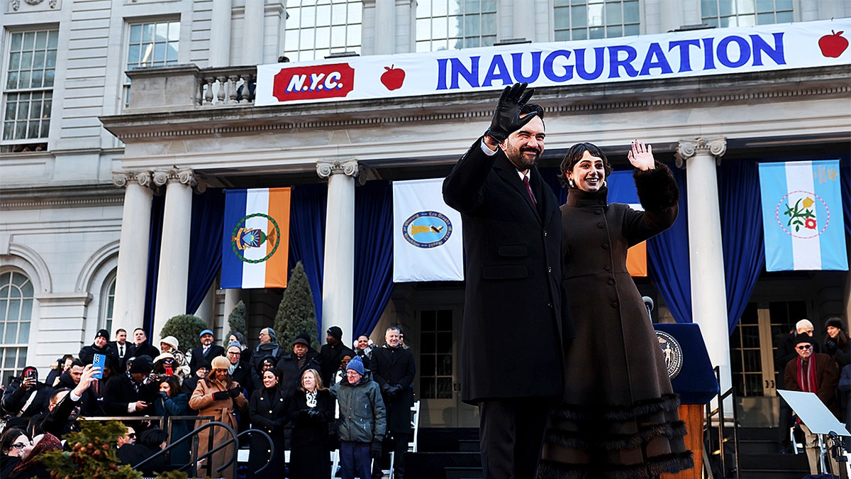 Zohran Mamdani and Rama Duwaji standing together on a stage at City Hall.