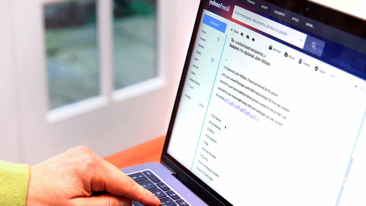 A laptop screen shows a phishing email.