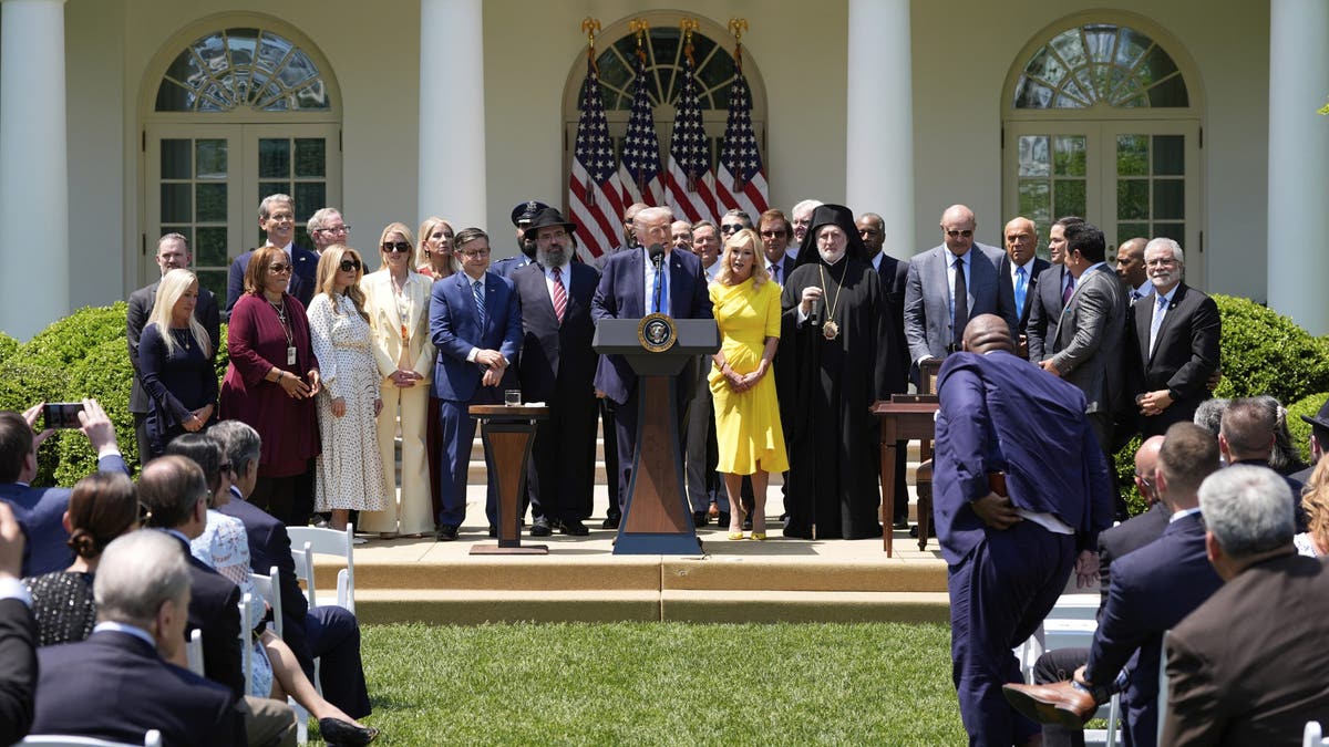 President Donald Trump calling people to the podium in the White House Rose Garden